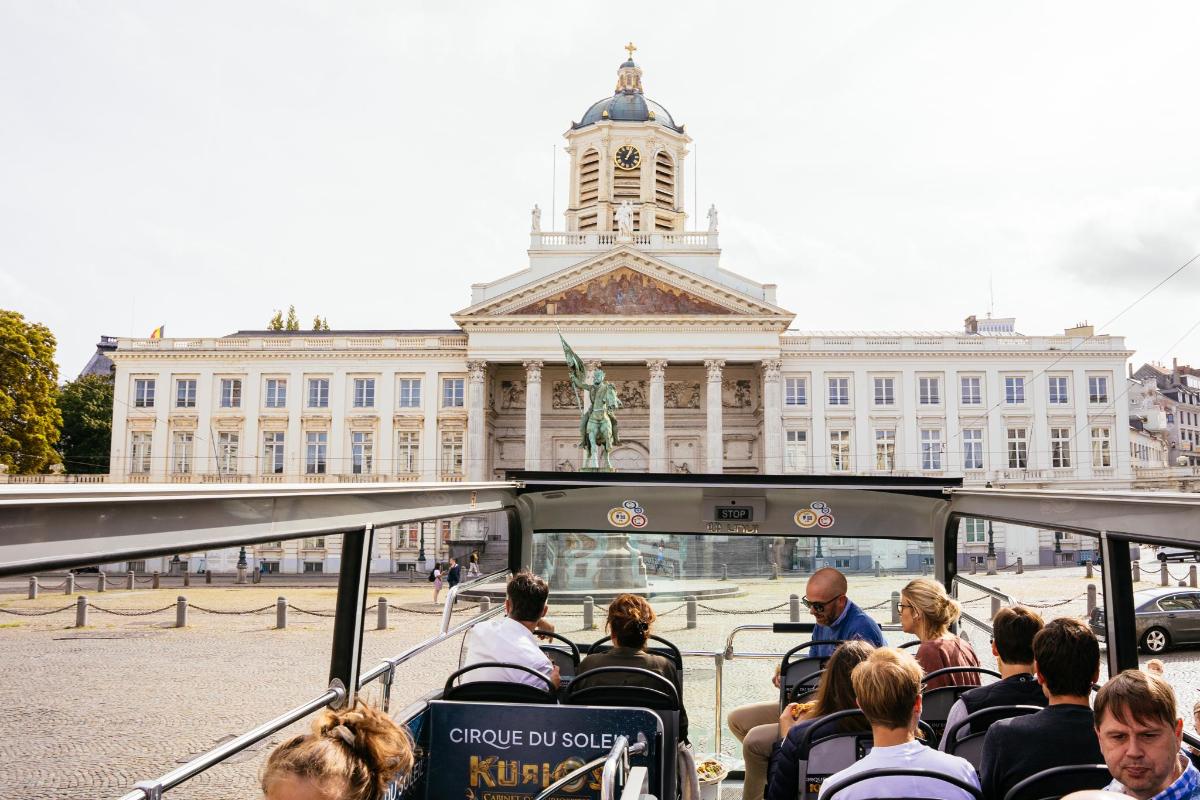 skupina lidí jedoucí v autobuse před budovou