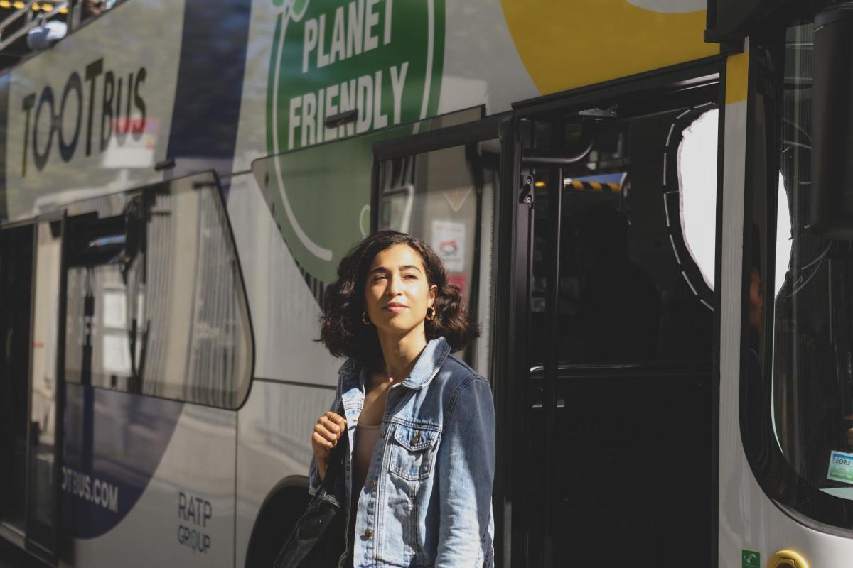 a woman standing in front of a bus