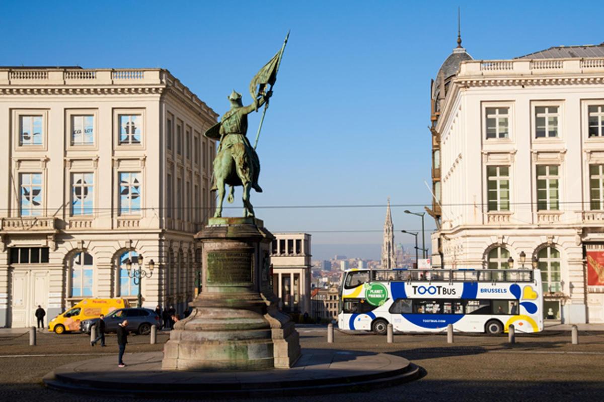 a statue in front of a building with a bus