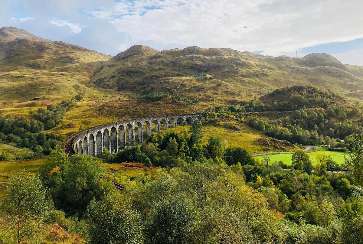 un ponte sopra una valle con le montagne sullo sfondo