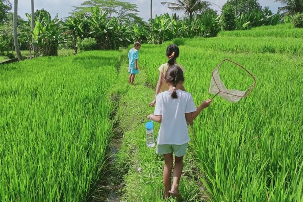 duas crianças caminhando em um campo com um guarda-chuva