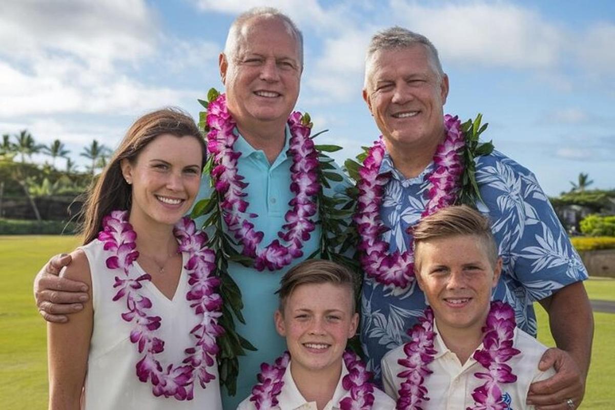 un uomo e la sua famiglia posano per una foto