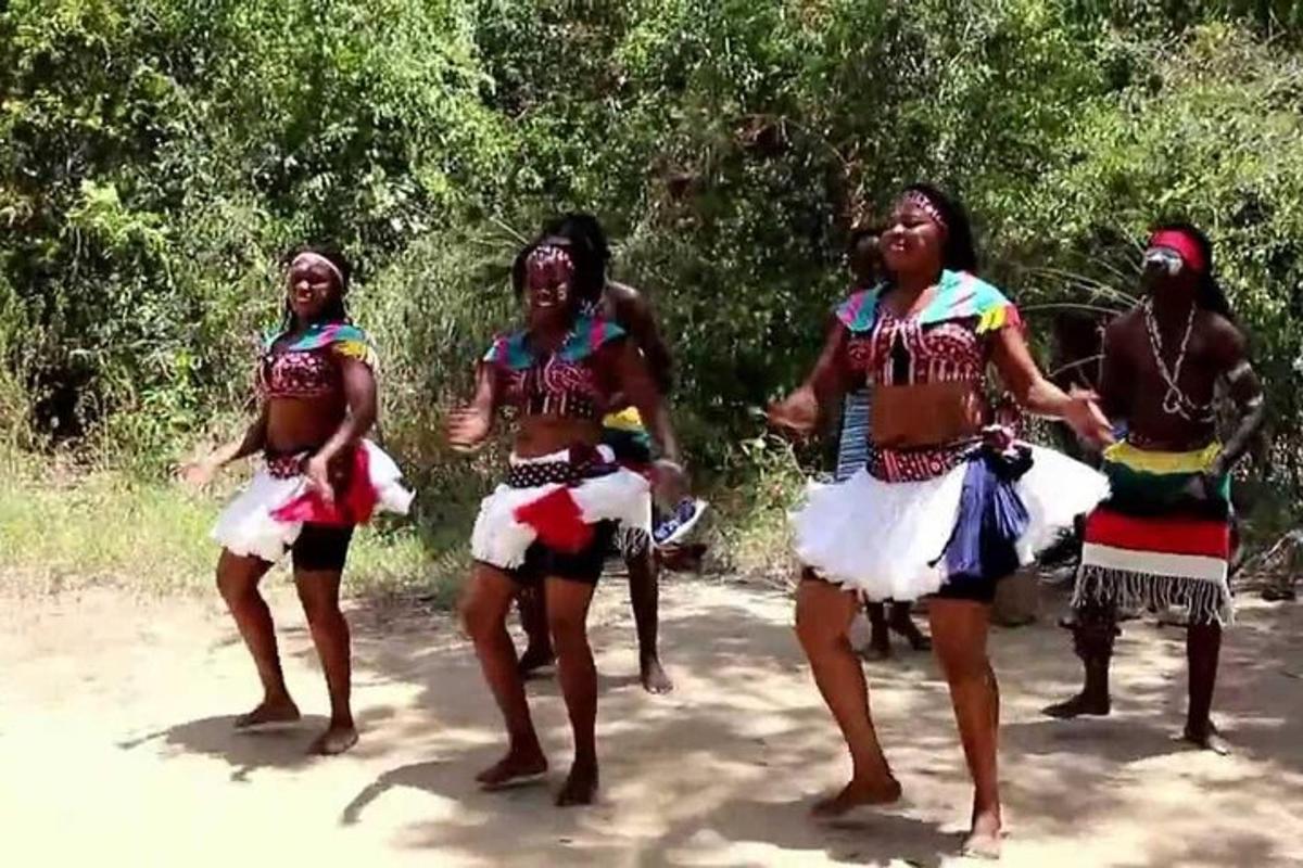 un grupo de mujeres bailando en un camino de tierra