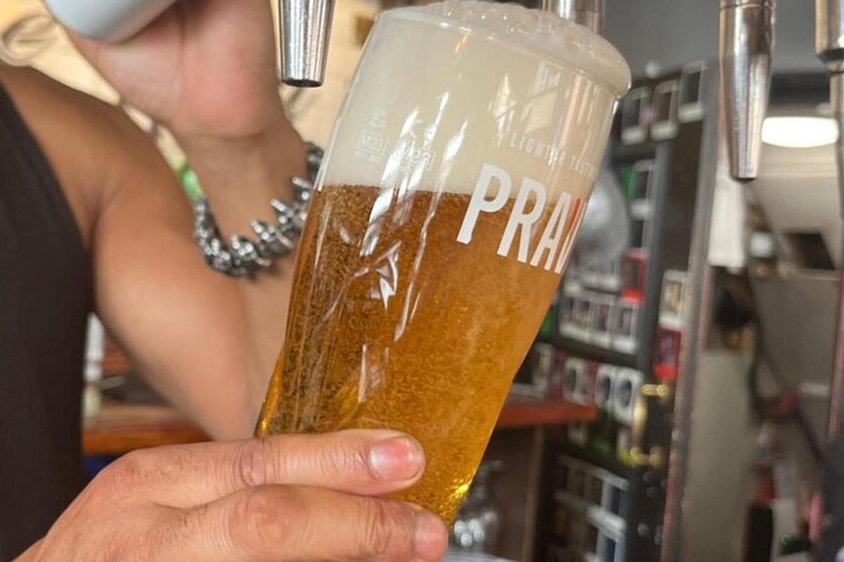 a woman is holding a glass of beer