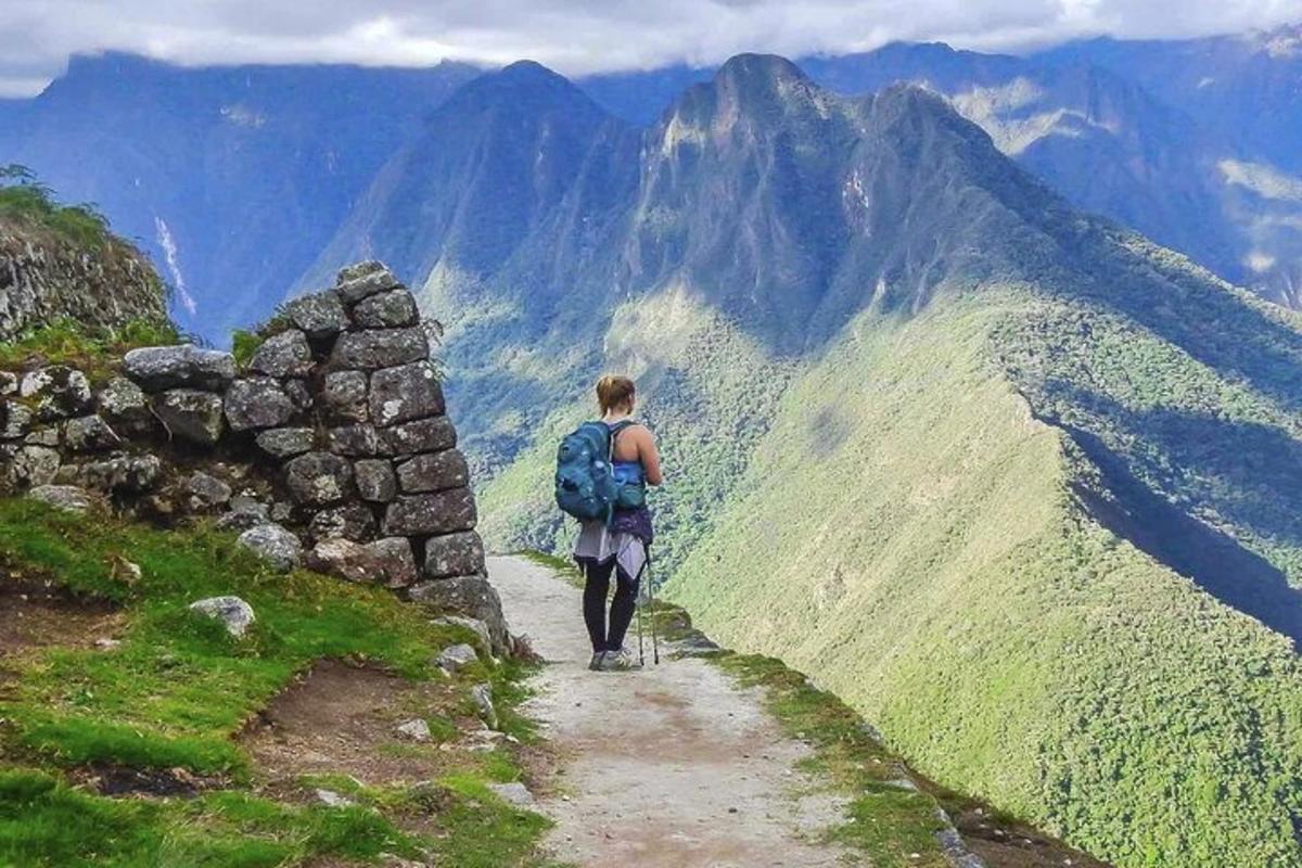 osoba s batohem kráčející po horské stezce