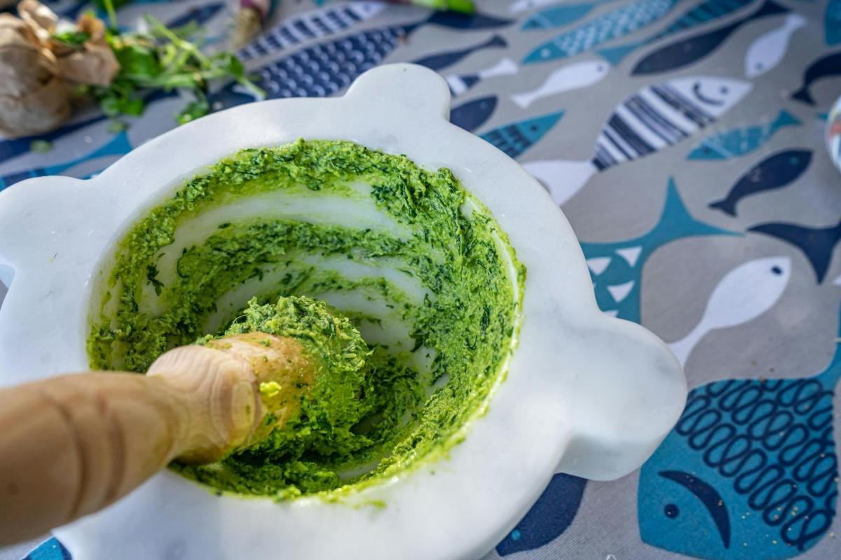 egy személy, aki zöld szószt tart egy fehér tálban