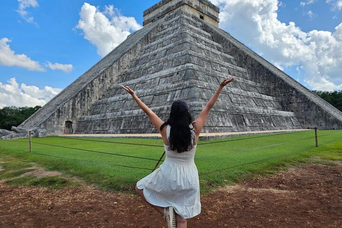 uma mulher de vestido branco em pé em frente a uma pirâmide