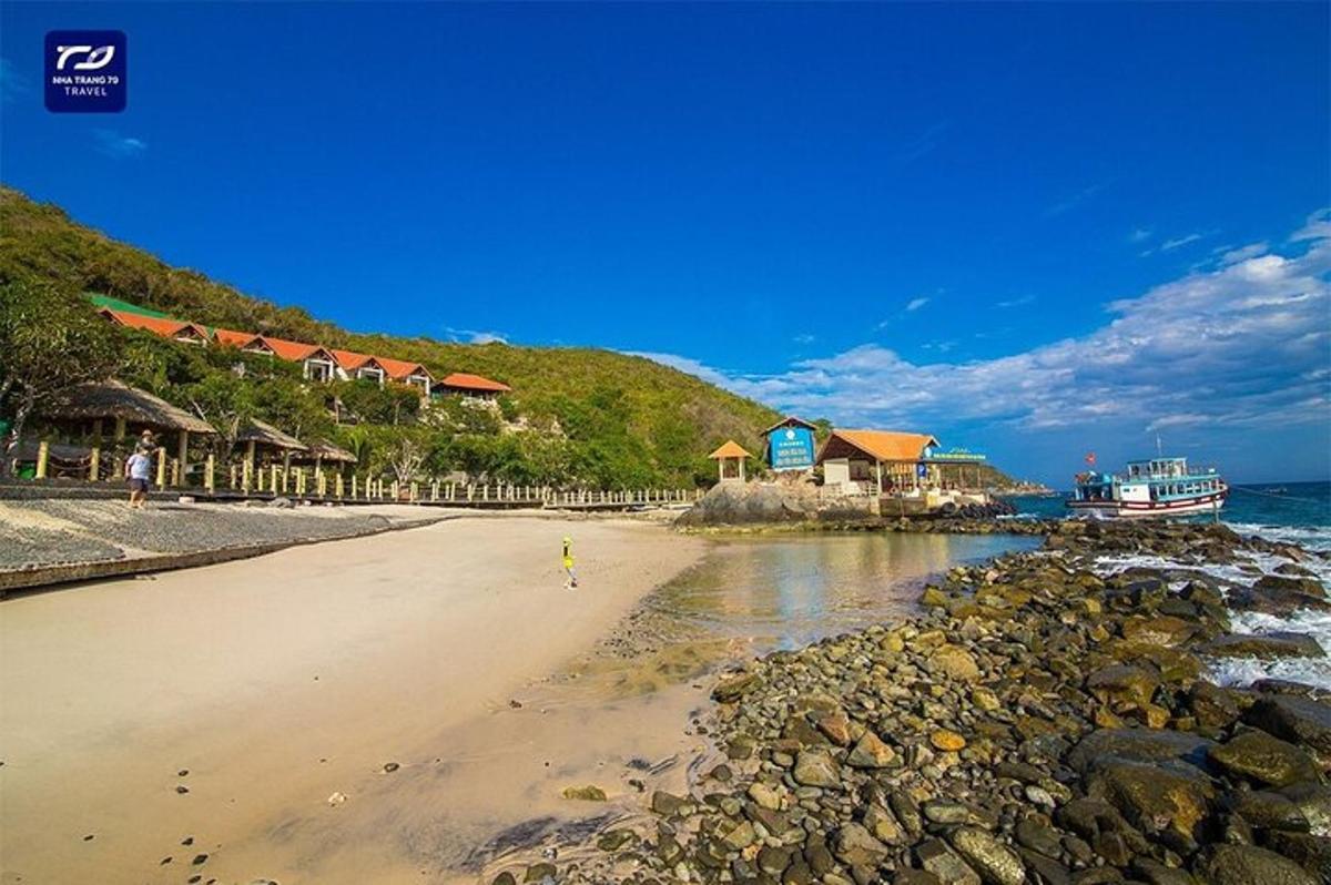 en strand med en gruppe hus og havet