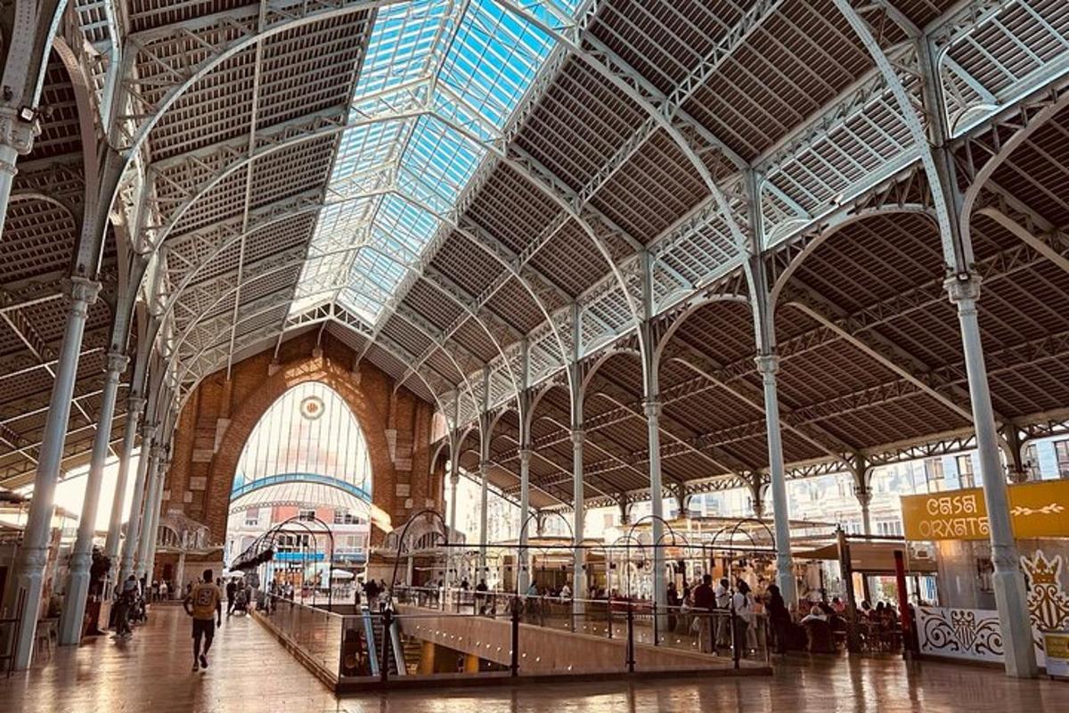 Una estación de tren con un gran edificio con gente dentro.