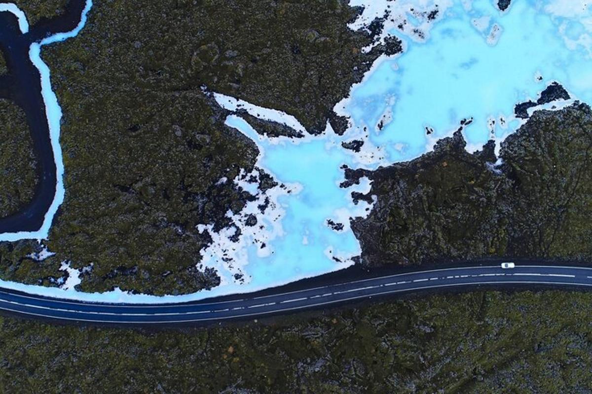 an aerial view of a road and blue water