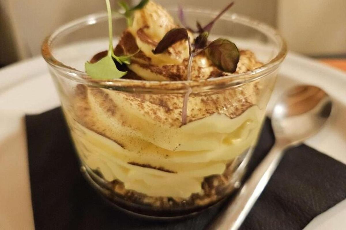 un dessert in un bicchiere su un piatto con un cucchiaio