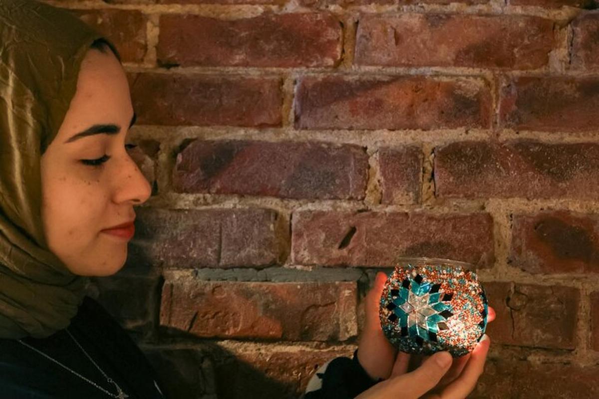 egy nő egy cupcake-et tart a kezében egy téglafal előtt