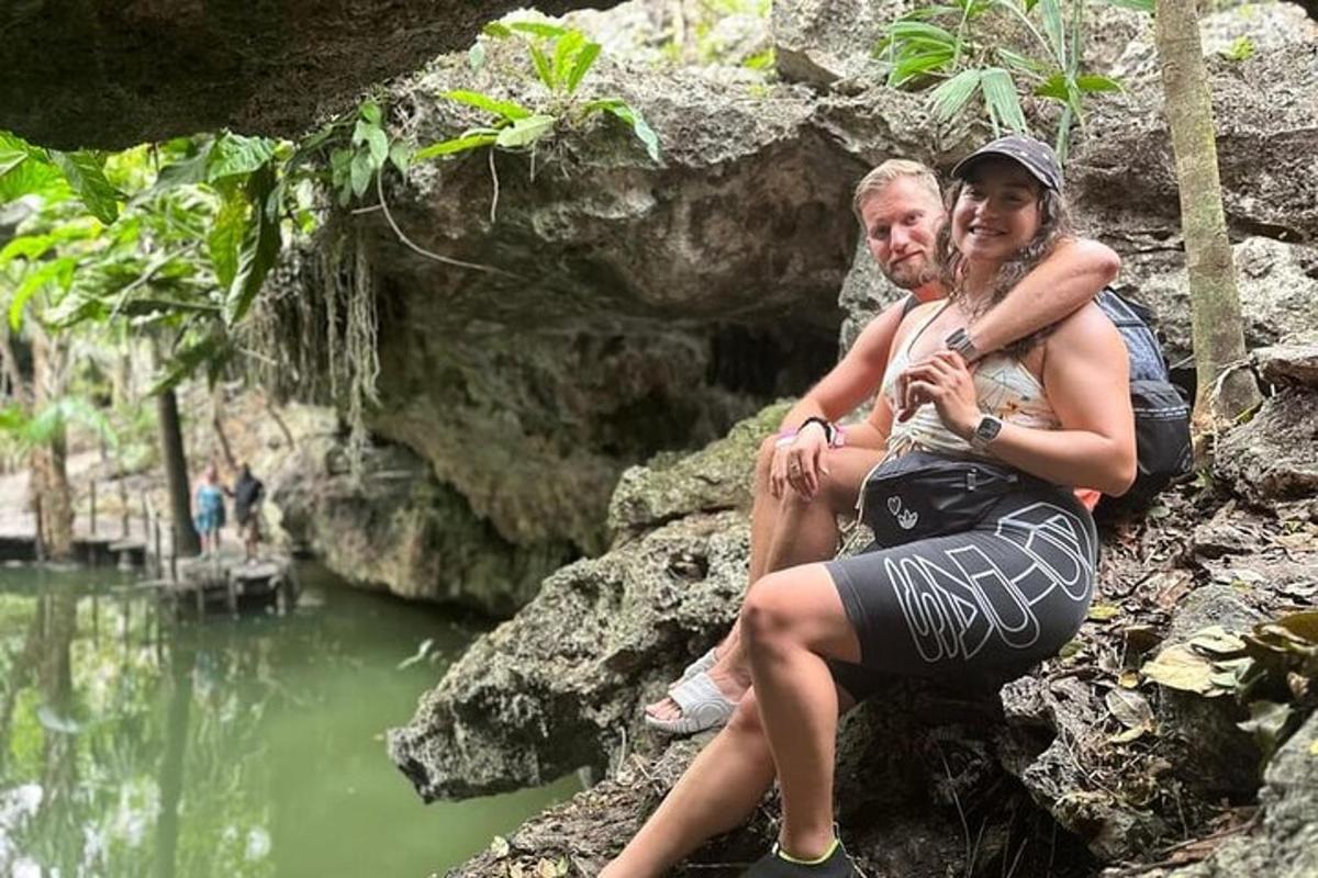un uomo e una donna seduti sulle rocce vicino a un fiume
