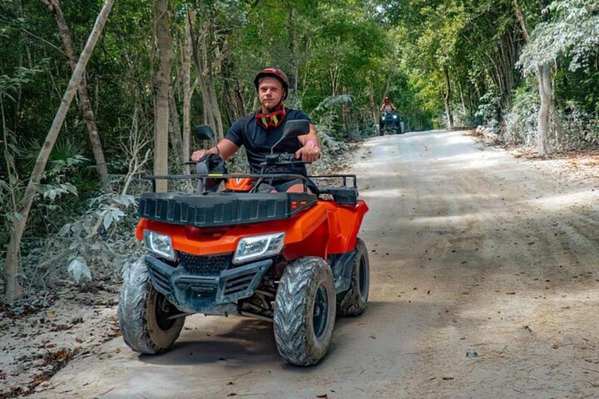 un uomo che guida un quad su una strada sterrata