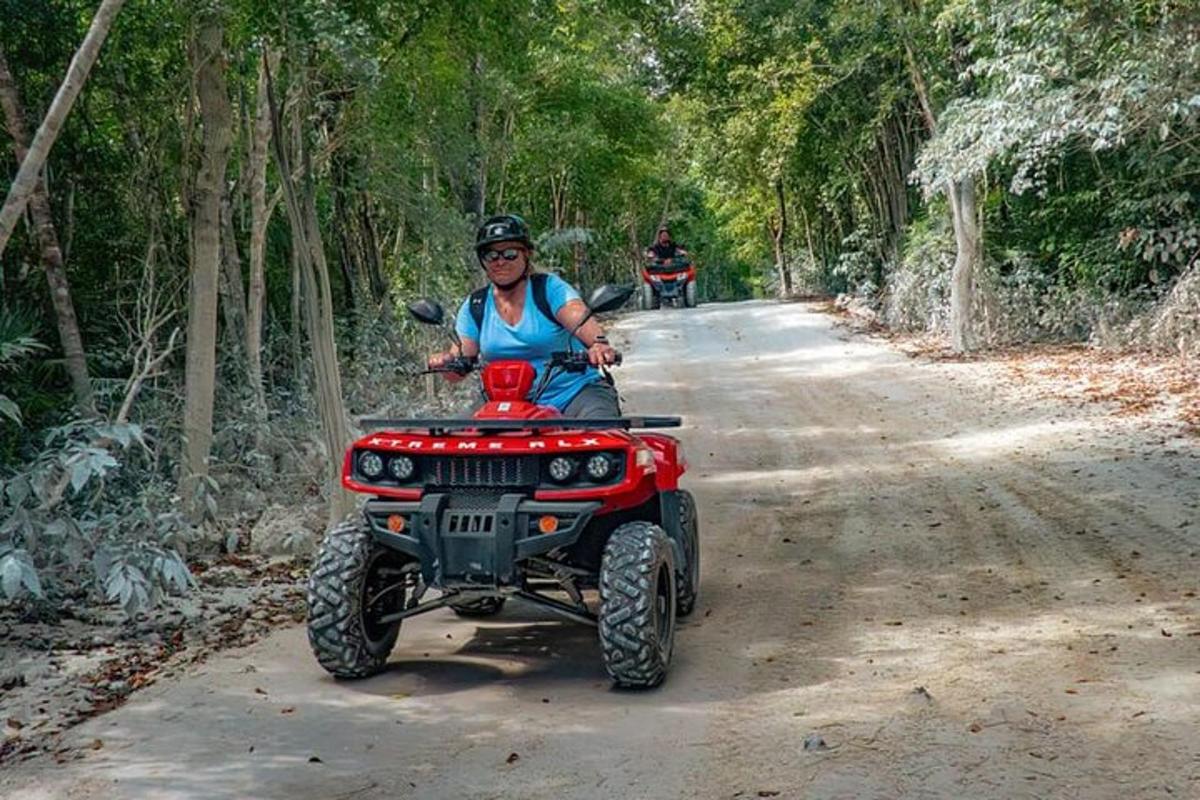 una donna che guida un quad rosso su una strada sterrata