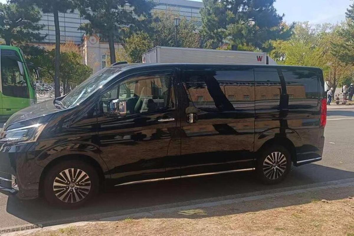 čierna dodávka zaparkovaná na kraji ulice