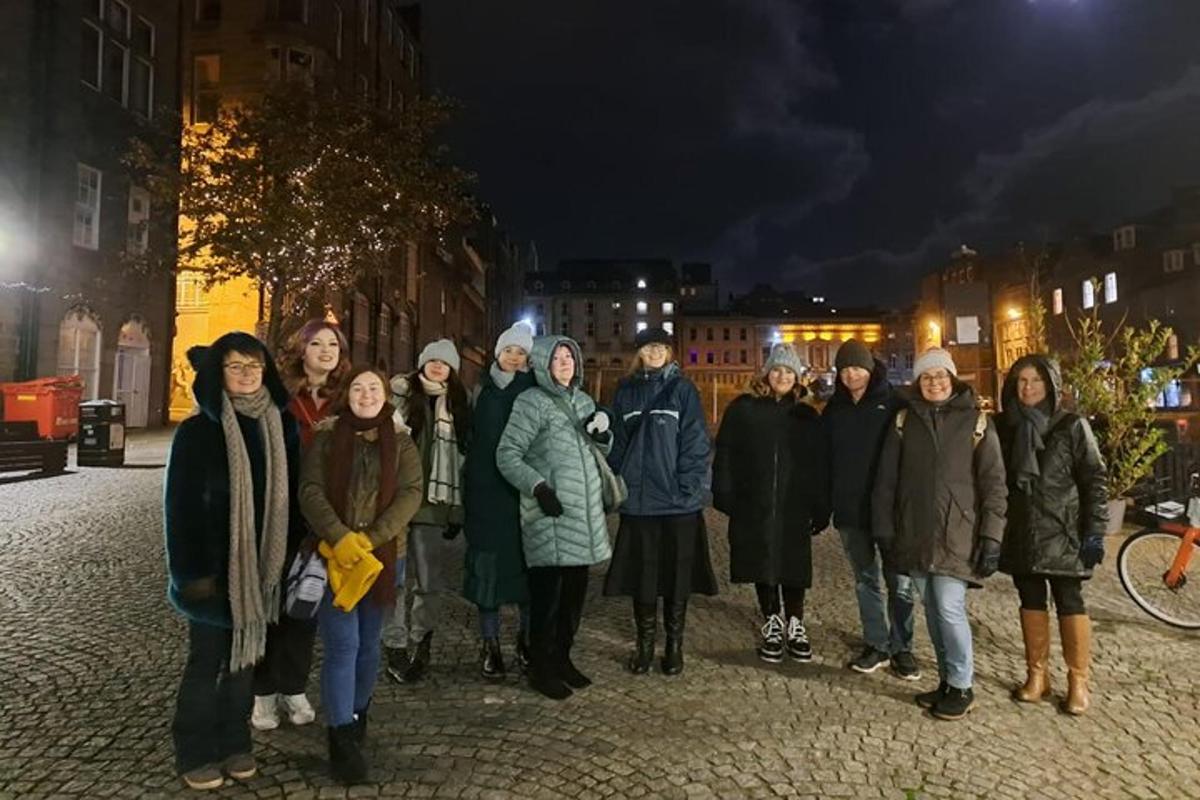 skupina lidí stojících v noci na ulici