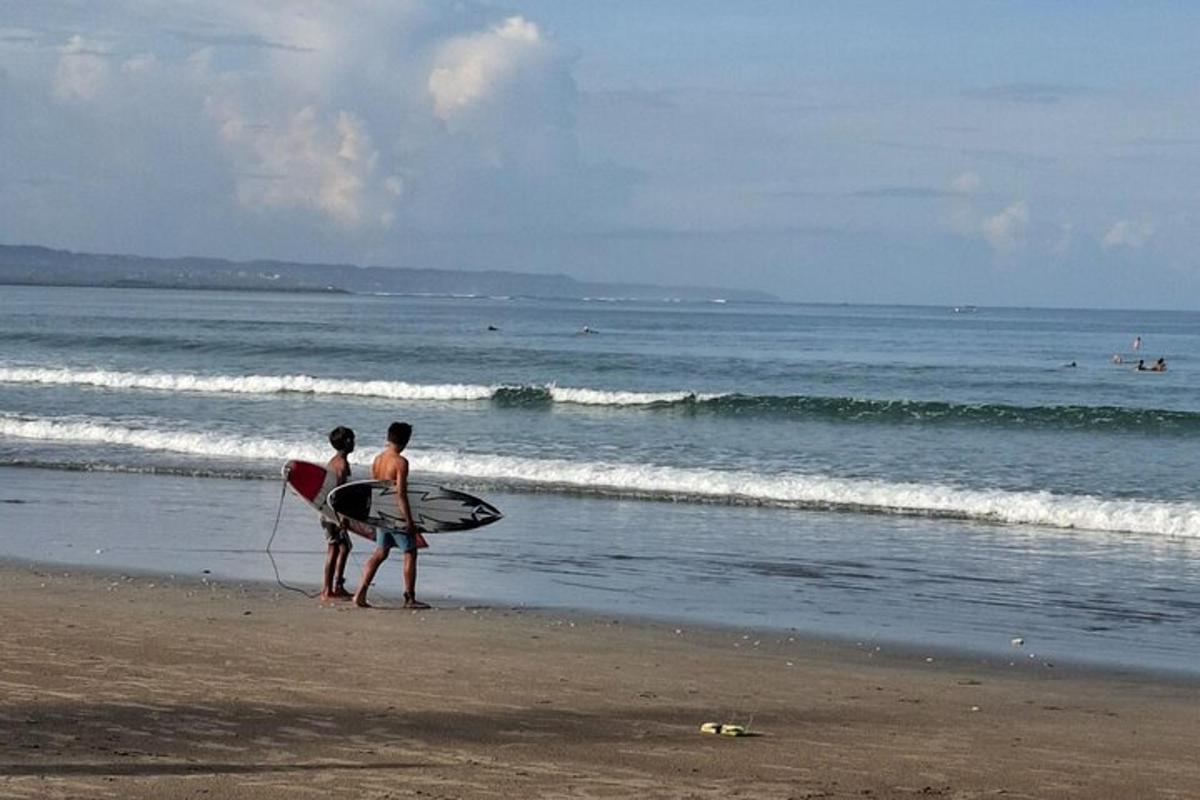 คนสองคนยืนอยู่บนชายหาดพร้อมกระดานโต้คลื่นของพวกเขา