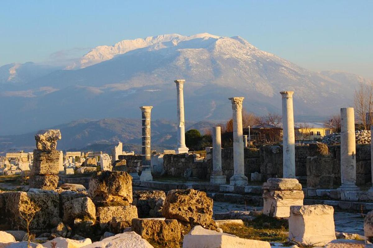 un gruppo di colonne con una montagna sullo sfondo