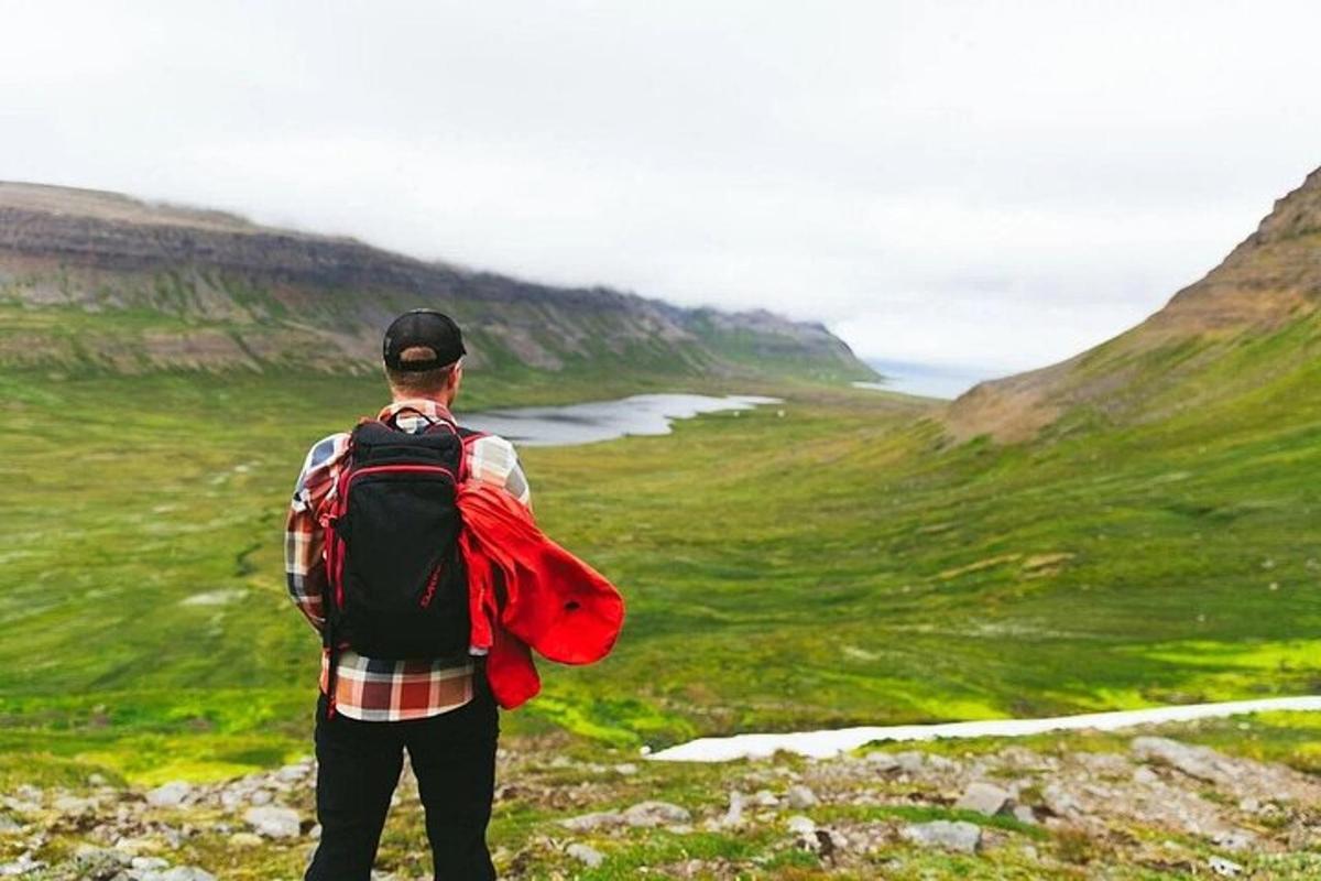 a man with a backpack standing on top of a mountain