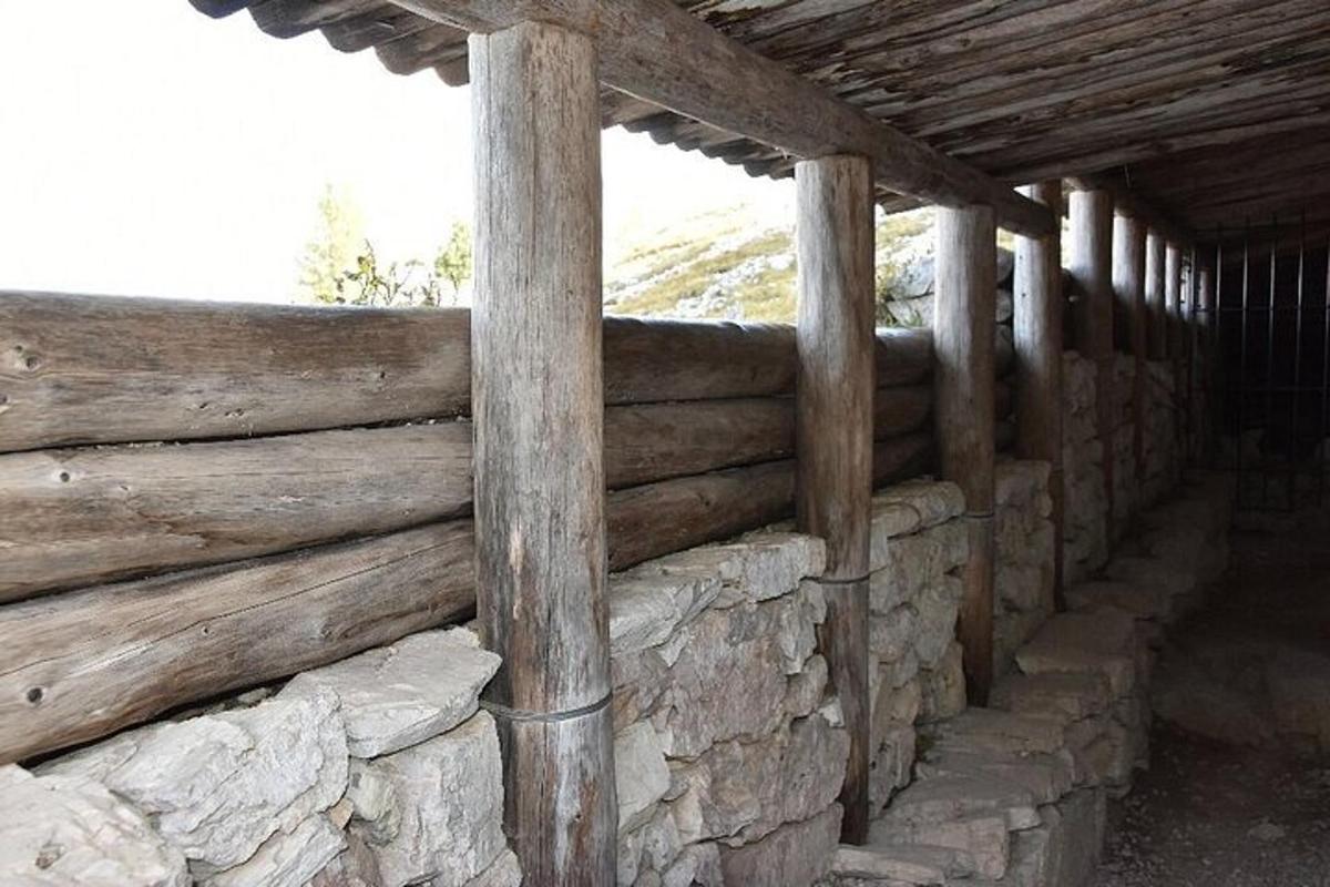 a wooden fence in front of a stone wall