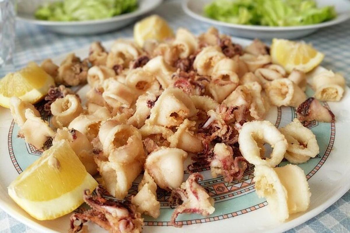 talíř jídla s krevetami a citrony na stole