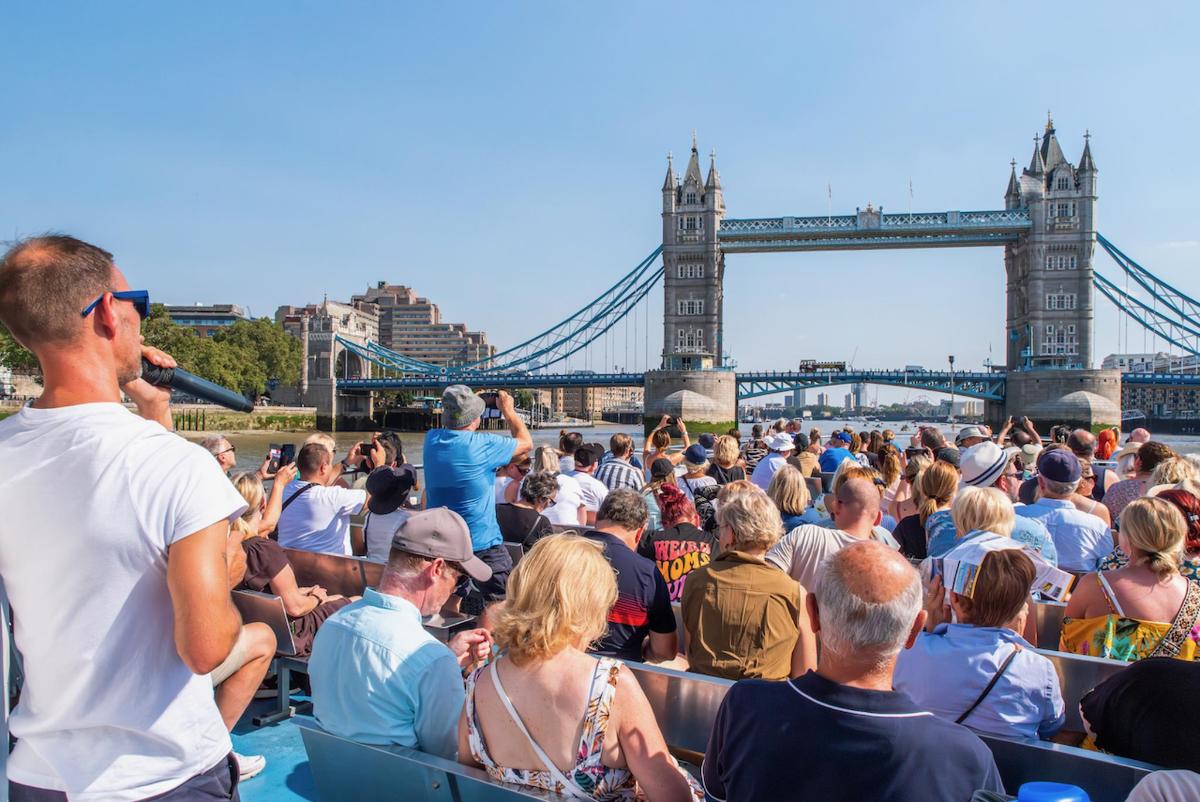 a crowd of people watching a concert in front of the tower bridge