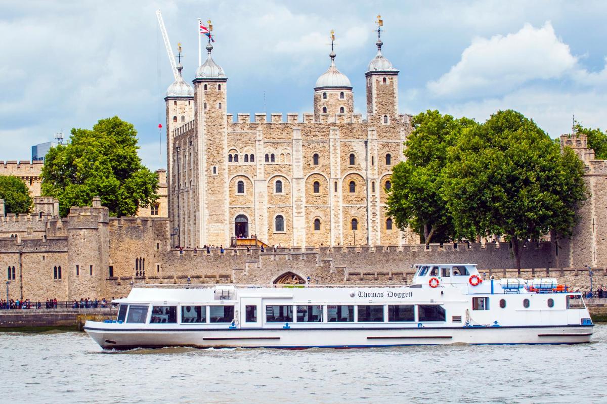 a boat on the water in front of a castle