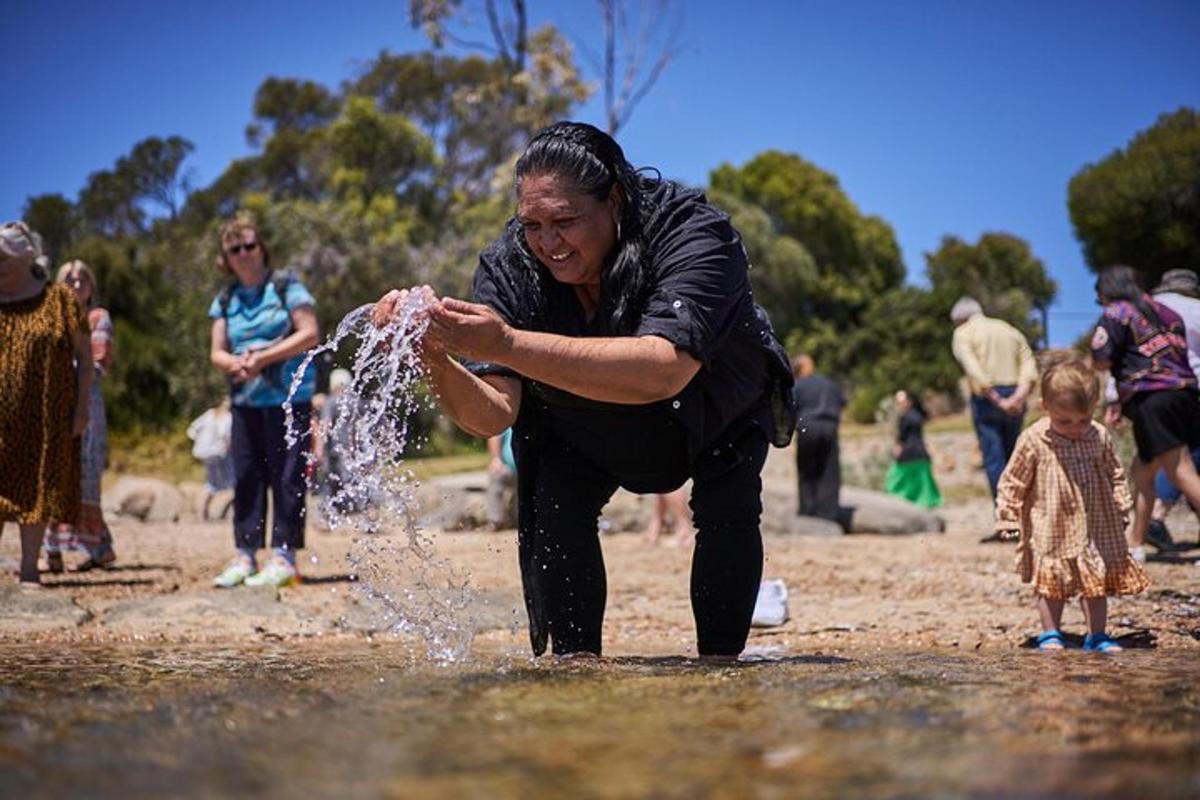 a woman is playing with water in a puddle