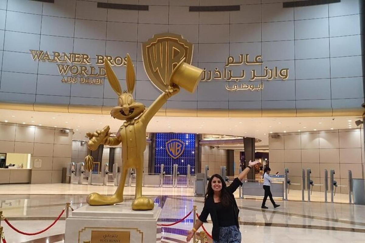 a woman posing in front of a golden trophy in a mall