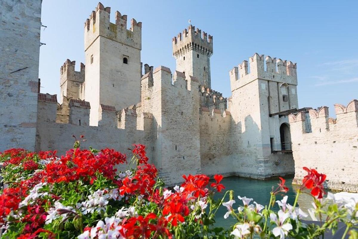 Un castillo con flores rojas delante.