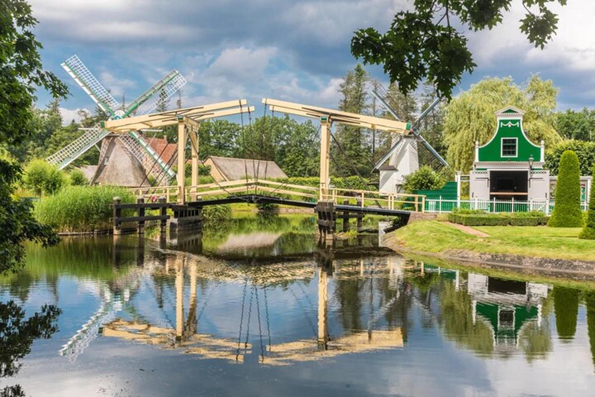 un ponte sopra un fiume con un mulino a vento