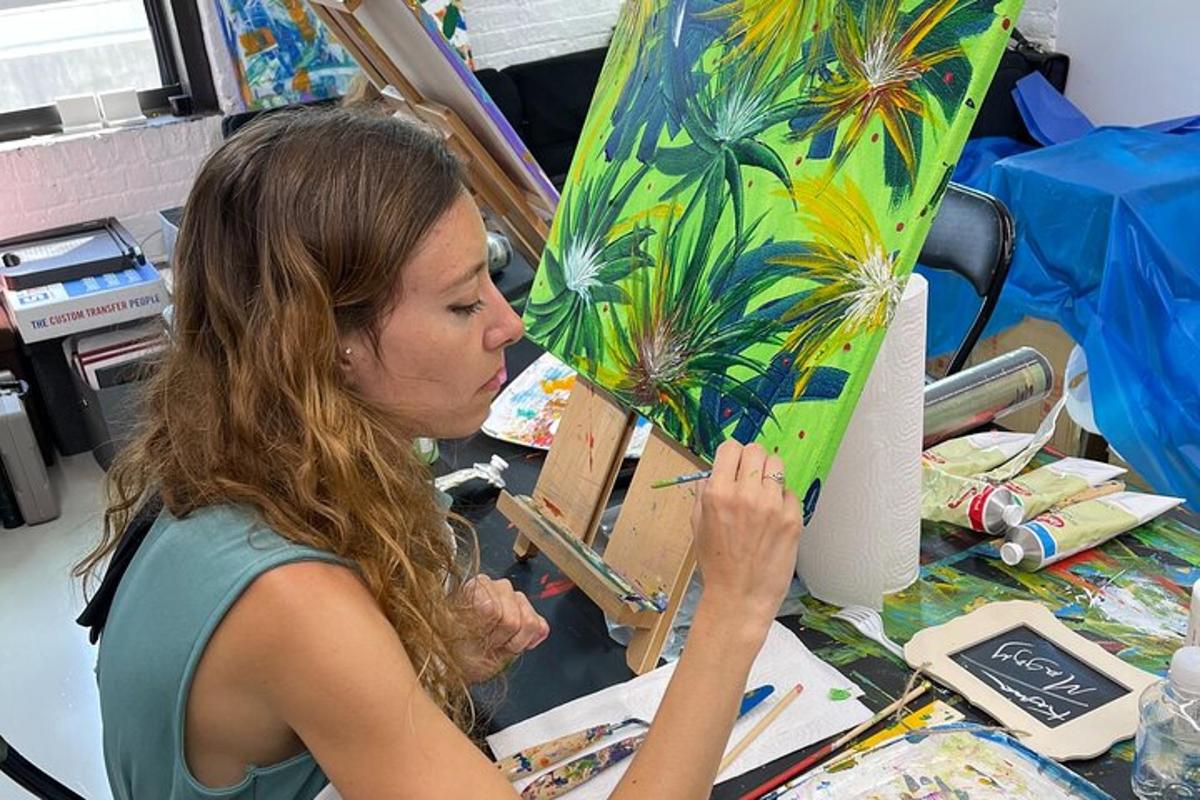 a woman working on a painting of a palm tree