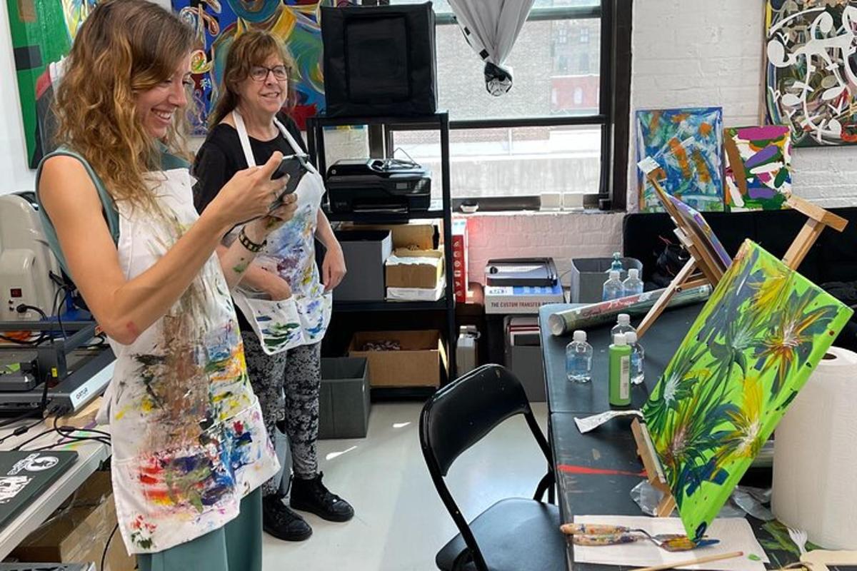 two women standing in a room with a painting
