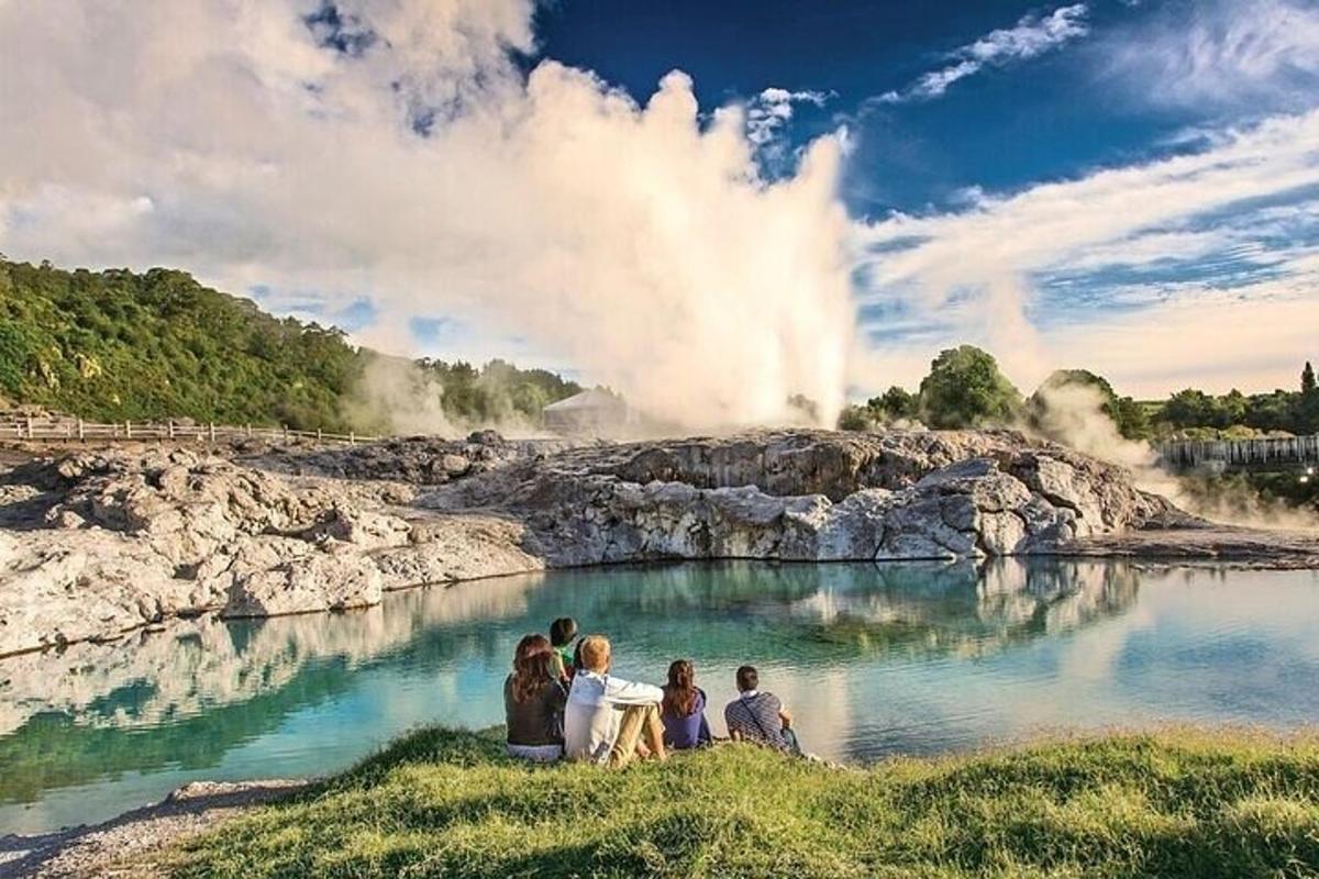 a group of people sitting in front of a geyser