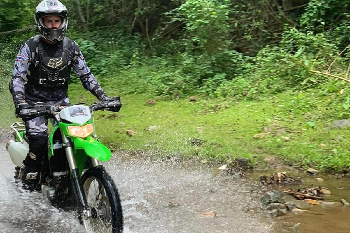 a man riding a motorcycle through a puddle of water