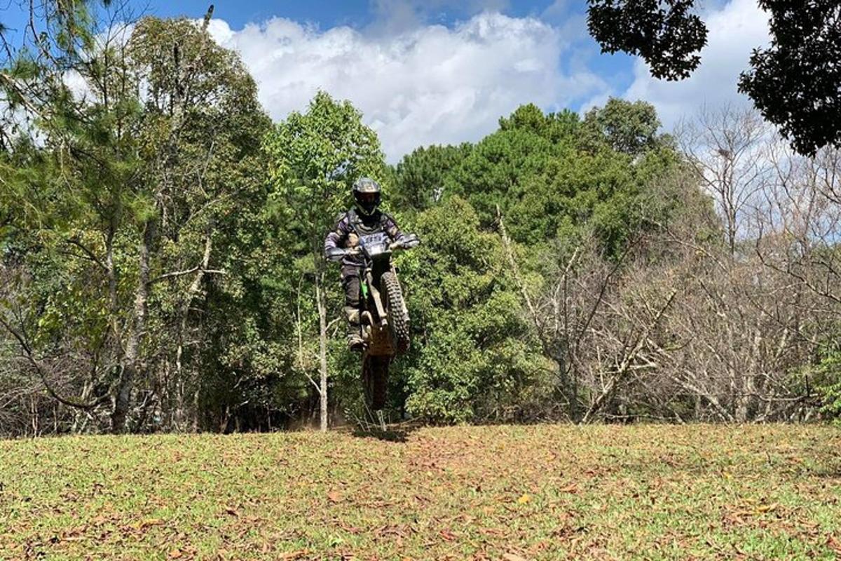 a person jumping a dirt bike in a field