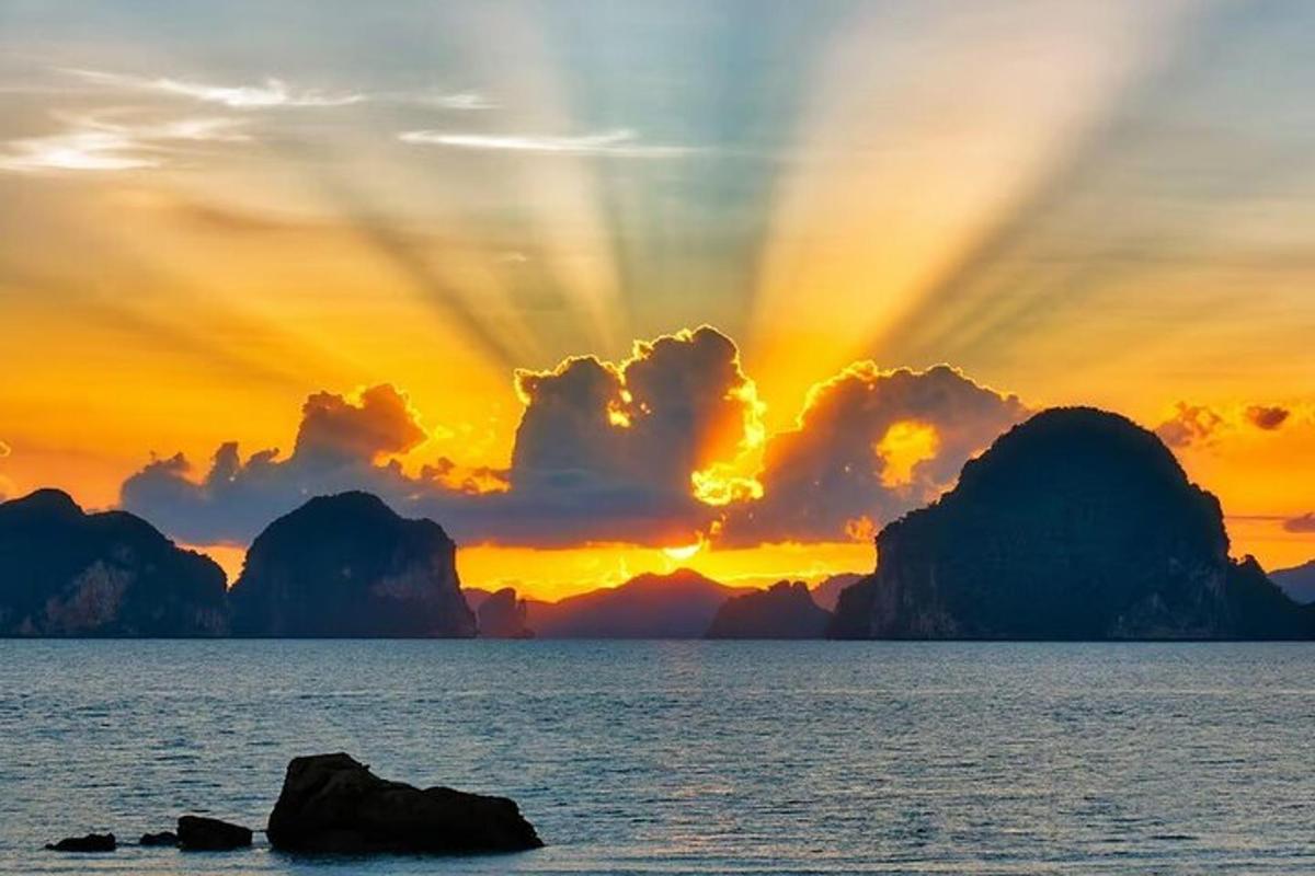 una posta de sol sobre l'oceà amb roques a l'aigua