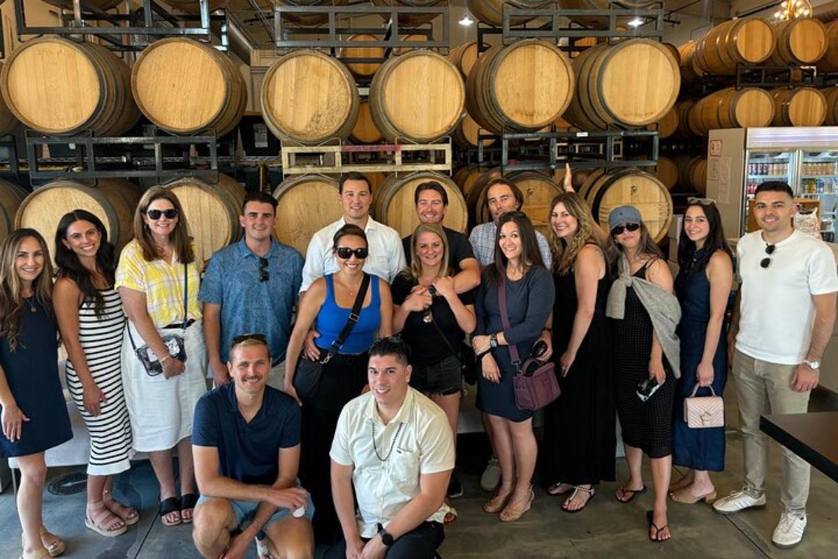 a group of people posing for a picture in a wine cellar