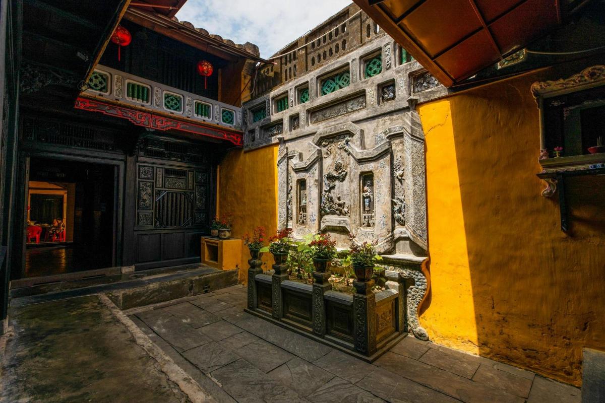 ein Gebäude mit gelben Wänden und Pflanzen in einem Innenhof