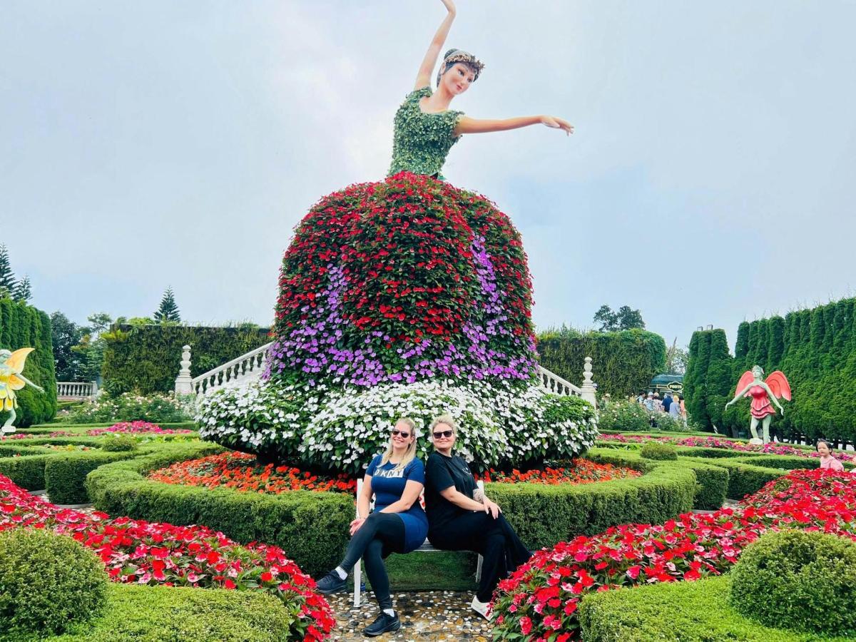 dva lidé sedící před květinovou zahradou