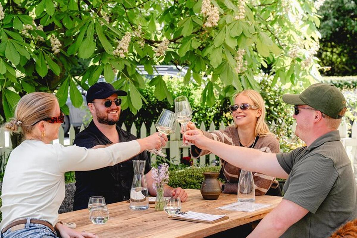 Un grupo de personas sentadas alrededor de una mesa bebiendo vino.