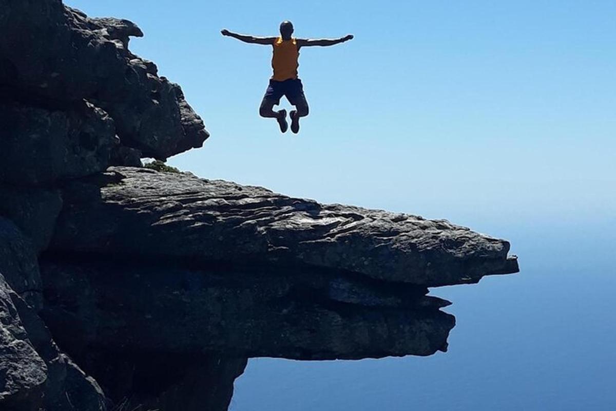 seorang lelaki melompat dari tebing ke dalam air