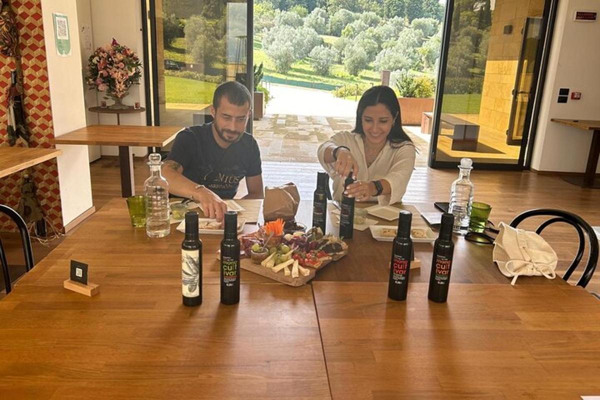 Ένας άντρας και μια γυναίκα κάθονται σε ένα τραπέζι με μπουκάλια κρασιού