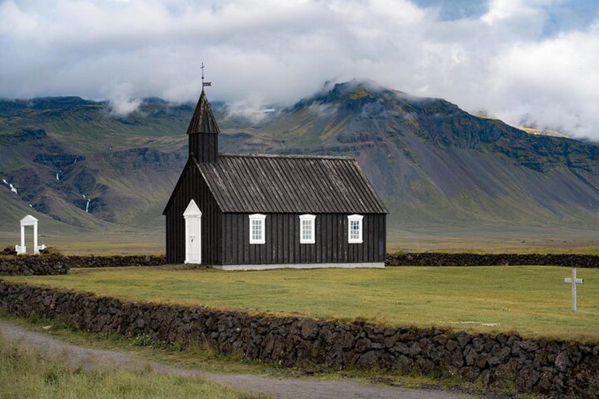 Svarthvít kirkja með fjalli í bakgrunni