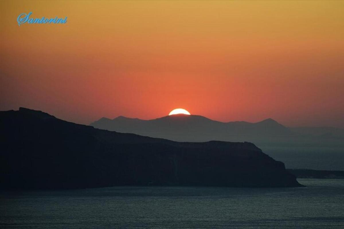Una puesta de sol sobre una montaña con el sol poniéndose detrás de ella
