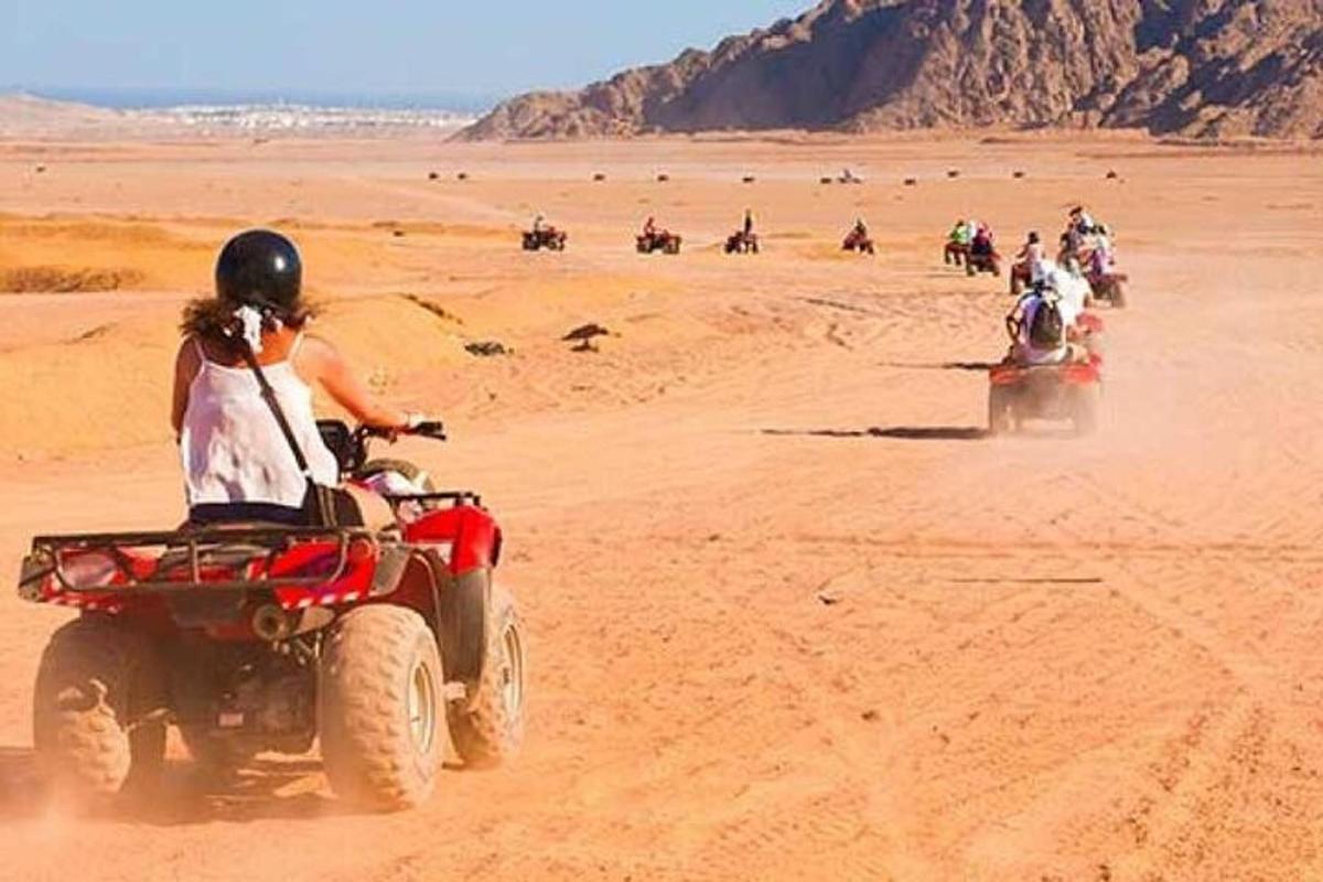 sekumpulan orang menunggang atv di padang pasir