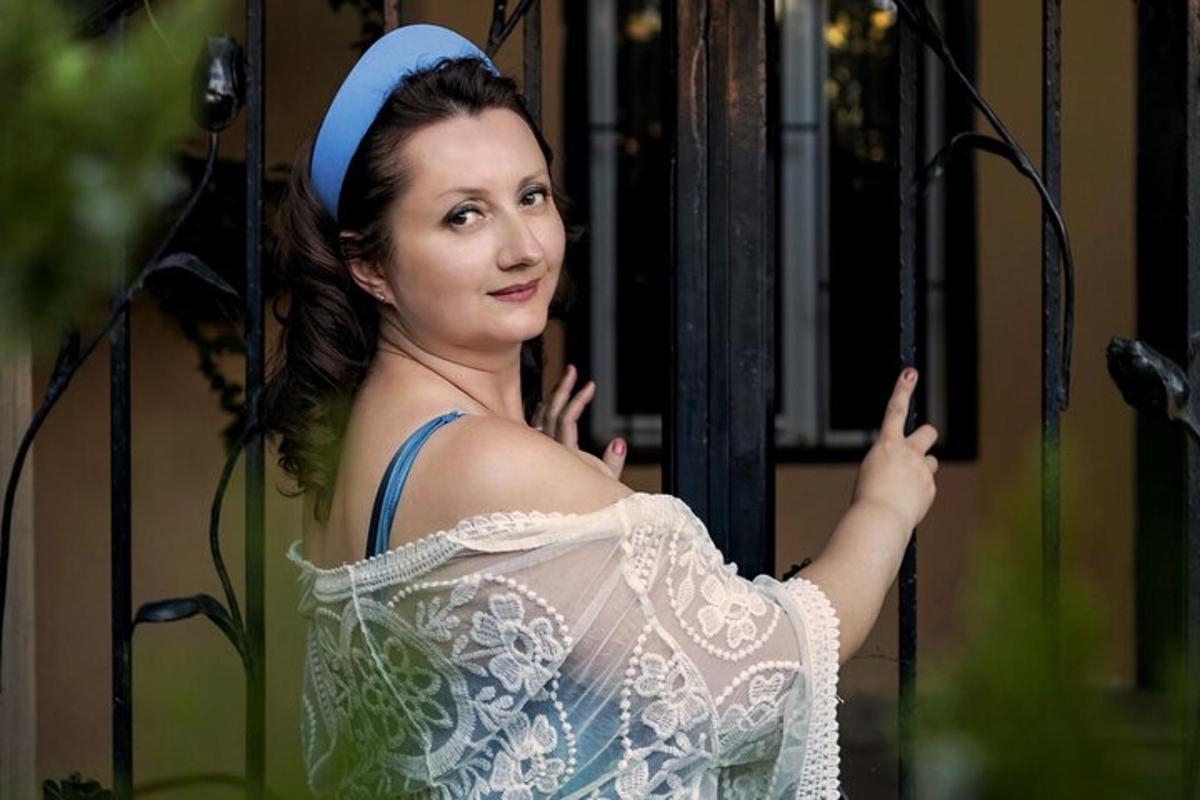 žena v šatech s modrou čelenkou