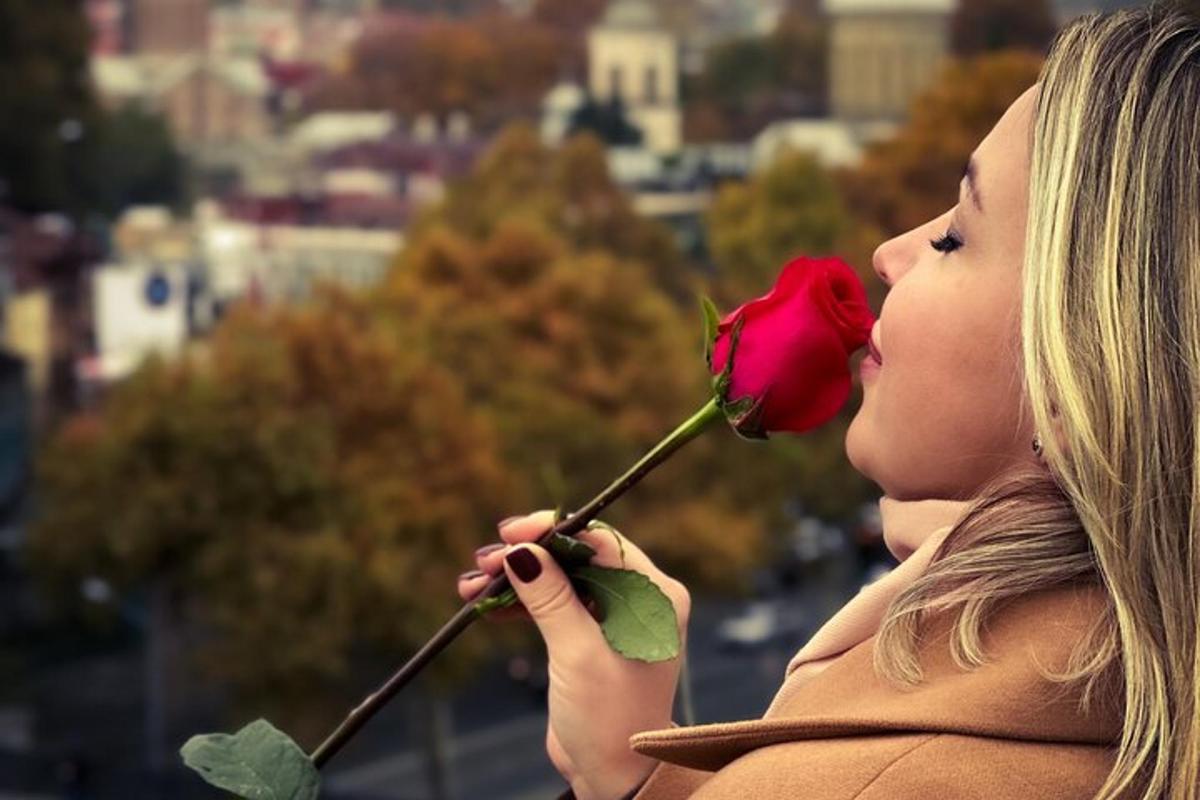 žena držící v ústech rudou růži