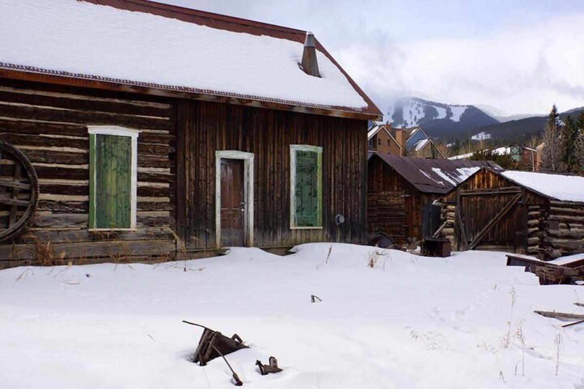 an old log cabin with snow on the ground